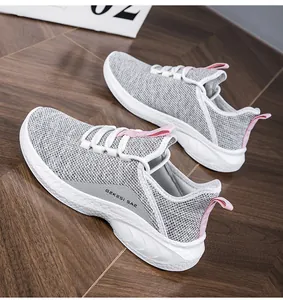Detailed close-up of breathable mesh upper and pink pull tab on grey casual sneakers