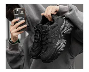 Close-up of black chunky dad sneakers featuring breathable mesh and thick rippled soles