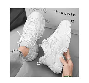 Close-up of white chunky sneakers with faux leather and mesh details for men
