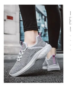 Detail of grey mesh running shoes with breathable fabric and purple pull tabs on street