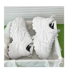 Detail view of white chunky sneakers with mesh panels and knitted sock collar branding