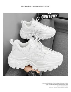 Detailed close-up of white chunky sneakers with mesh texture on a grey sofa