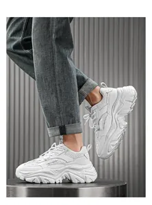 Close-up of white chunky sneakers with thick wavy soles on a fashion model