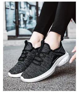 Side view of breathable black and white knit sneakers with thick cushioned white soles