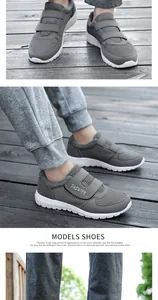 Details grauer atmungsaktiver Mesh-Schuhe mit doppeltem Klettverschluss auf Holz