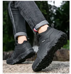 Detail view of durable non-slip rubber outsole on black outdoor hiking boots in nature