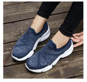 Detail of dark blue slip-on sneakers with breathable knit and white non-slip sole