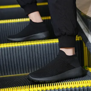 All-black breathable knitted sock sneakers for men and women on a moving escalator