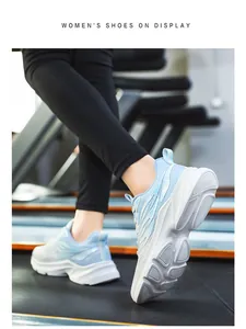 Close-up of blue and white mesh women's running shoes on a treadmill in a gym setting