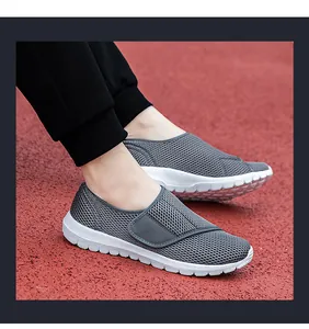Detail view of grey mesh breathable walking shoes with velcro straps on a red track