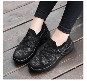 Detail of black slip-on sneakers featuring breathable knit fabric and star patterns