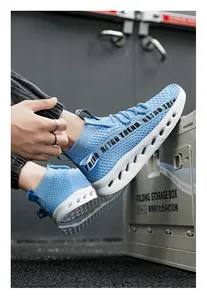 Dettaglio scarpa sportiva in maglia azzurra con cinturino retro e suola ammortizzata