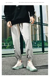 Street style shot of black hoodie and cream joggers highlighting fabric texture and fit