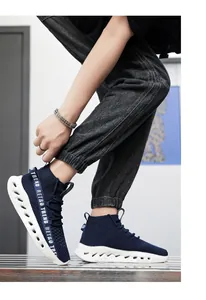 Dettaglio sneaker alta in maglia blu navy con suola bianca traforata e cinturino retro trend