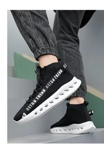 Dettaglio sneaker nera in maglia con cinturino Retro Trend e suola ondulata traforata