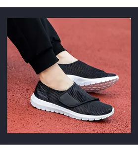 Detail of black mesh upper with adjustable hook-and-loop strap on athletic walking shoes