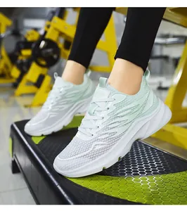 Detailed close-up of mint green breathable mesh sneakers on a gym fitness platform