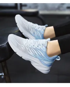 Dynamic side view of breathable gradient blue mesh running shoes worn in a gym