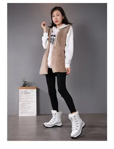 Outdoor lifestyle view of high-top snow boots with cozy white plush lining and thick soles