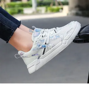 Détails de baskets en maille respirante blanche avec motifs marbrés bleu et violet