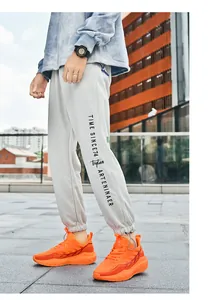 Detail of grey jogger pants with printed graphics and elastic cuffs for sporty look