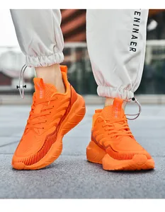 Close-up of vibrant orange breathable mesh running shoes on-feet for outdoor sports