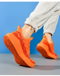 Macro view of orange running shoes with thick cushioned sole and anti-slip wavy pattern