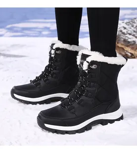 Outdoor shot of black waterproof snow boots with white faux fur lining and thick rubber soles