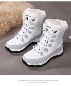Close-up of white quilted snow boots with thick faux fur lining and outdoor soles