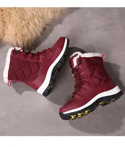 Macro shot of waterproof burgundy winter boots with quilted fabric and warm faux fur lining