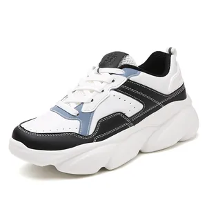 Sneakers alla moda con suola spessa in bianco, nero e blu con design patchwork