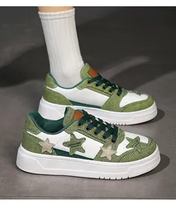 Detalle de tela vaquera verde y cuero blanco en zapatillas de plataforma con parches de estrellas