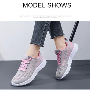 Detail view of breathable grey mesh running shoes with pink laces and thick white rubber sole