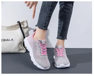 On-foot view of breathable gray and pink running shoes with striped mesh texture