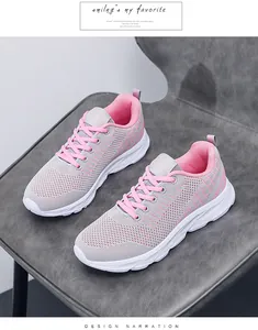 Close-up of grey mesh sneakers with pink accents on a grey leather seat with natural lighting