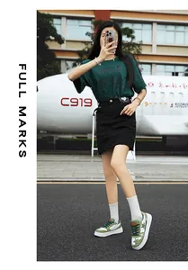 Zapatillas verdes con estrellas y falda vaquera negra con etiqueta de corazón al aire libre