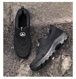 Detailansicht der schwarzen Outdoor-Slipper für Herren mit Profilsohle auf Felsen