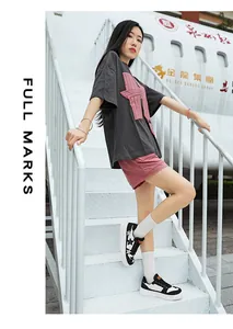 Detalle de camiseta gris extragrande con parche de estrella rosa y pantalones cortos a juego