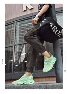 Detail of mint green mesh athletic sneaker with wave hollow sole on modern street background