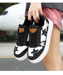 Detalle de zapatillas modernas en blanco y negro con parche de estrella y suela