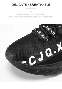 Dettaglio del tessuto mesh traspirante nero su sneaker alla moda con scritte laterali