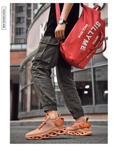 Detail view of orange woven mesh sneakers with hollow wavy thick soles for street style