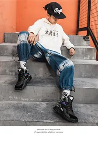 Dettaglio di sneaker alta nera con accenti rossi e blu indossata da un modello street style