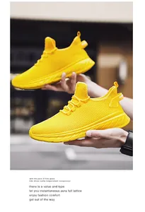 Detail of breathable yellow mesh sneakers with drawstring laces and nylon heel pull tabs
