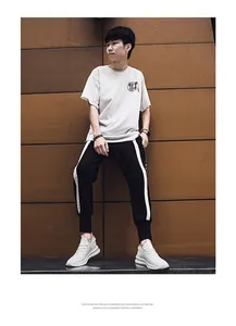 Men's stylish outfit featuring a white T-shirt with black joggers and thick-sole sneakers