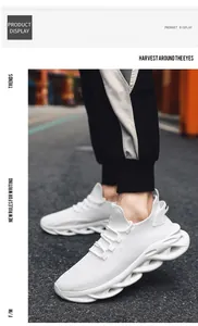 Detalle de zapatillas blancas de malla transpirable con suelas gruesas onduladas en la calle