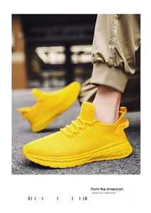 Detail view of breathable yellow mesh fabric and durable thick rubber sole on sports shoes