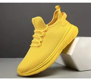 Close-up of bright yellow mesh running shoe featuring breathable large eyelet fabric texture