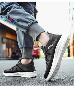 Outdoor-Aufnahme von atmungsaktiven Herren-Sportschuhen aus Flyknit mit weißen MD-Sohlen