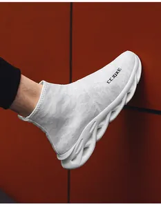 Dettaglio sneakers in maglia bianca con suola spessa ondulata e logo laterale